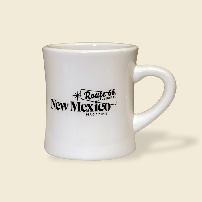 White mug with 'Route 66 New Mexico Magazine' text on a beige background